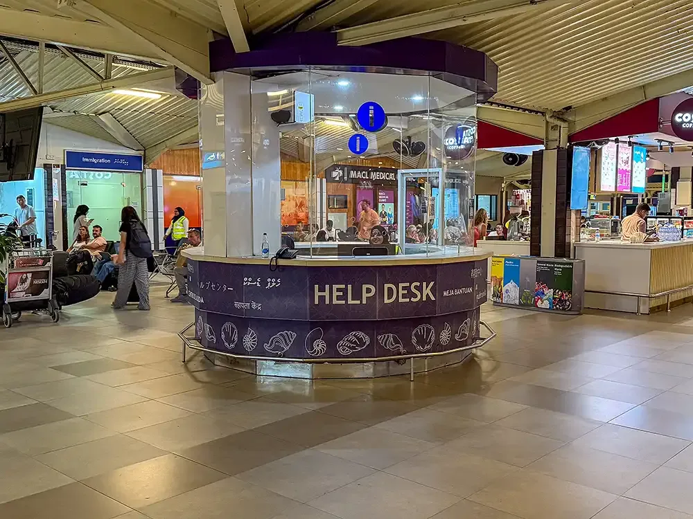 Intérieur d'un aéroport avec un comptoir d'information et des voyageurs