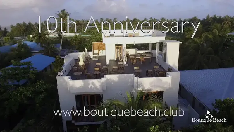 Bâtiment blanc moderne avec terrasse sur le toit et végétation tropicale