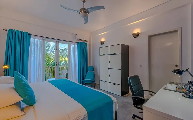 Chambre d'hôtel lumineuse avec vue sur la mer et décoration turquoise