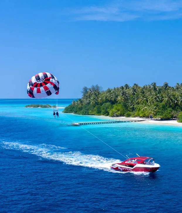 Deux personnes en parachute ascensionnel tirées par un bateau rapide