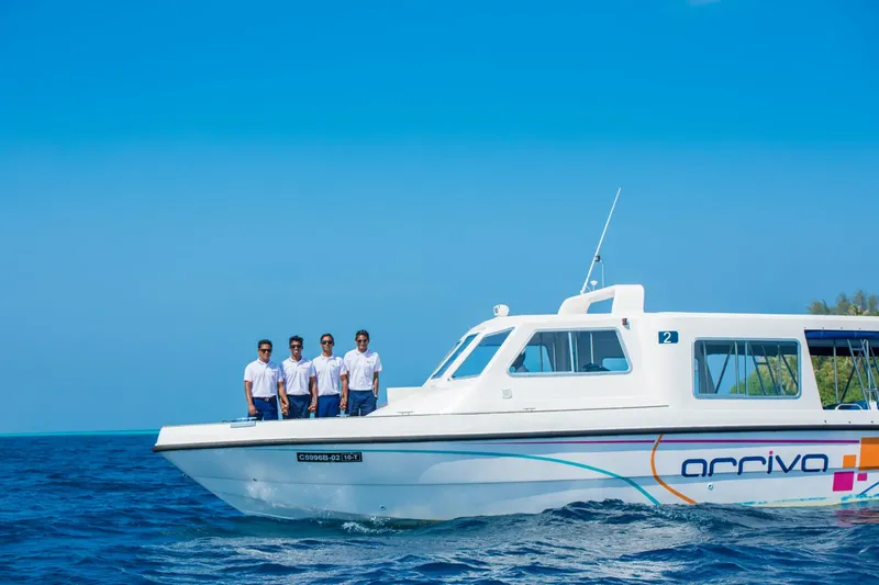 Quatre personnes debout sur la proue d'un bateau blanc en mer