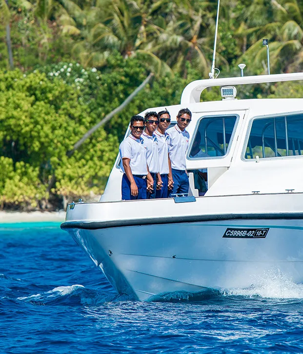 Quatre hommes regardent depuis un bateau blanc sur l'océan bleu