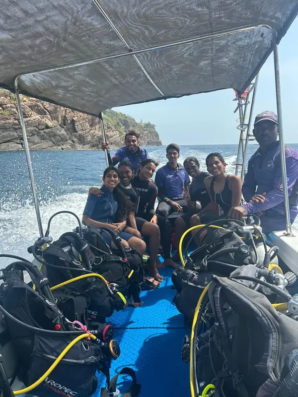 Groupe de plongeurs souriants à bord d'un bateau semi-rigide en mer