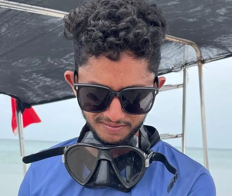 Homme souriant portant un masque de plongée sur un bateau