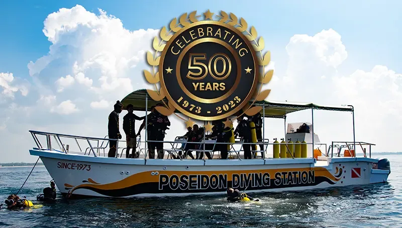 Bateau de plongée avec des plongeurs et un logo célébrant 50 ans