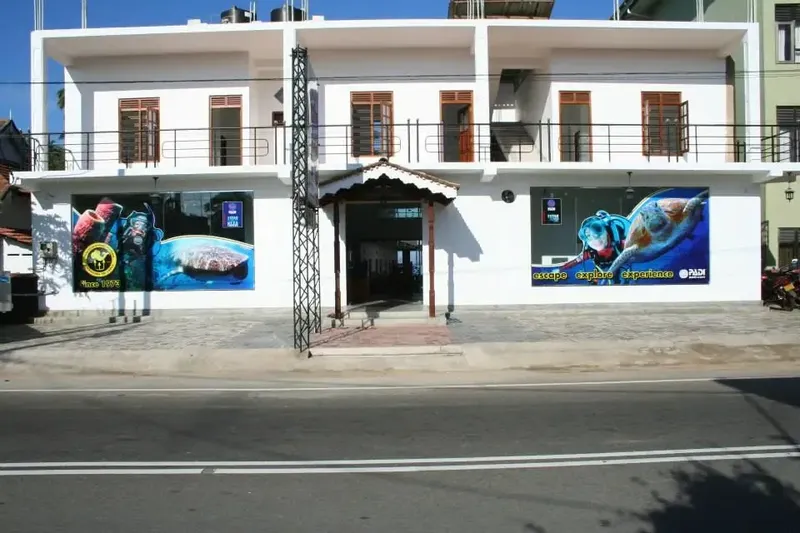 Façade d'un bâtiment blanc avec des affiches de plongée colorées