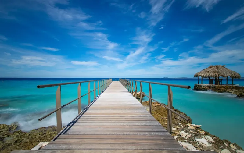 Ponton en bois menant à une structure sur l'eau mer turquoise