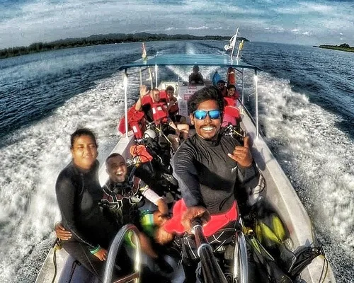 Groupe de plongeurs souriants sur un bateau en pleine navigation