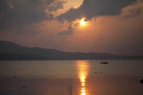 Coucher de soleil sur la mer avec un bateau au loin