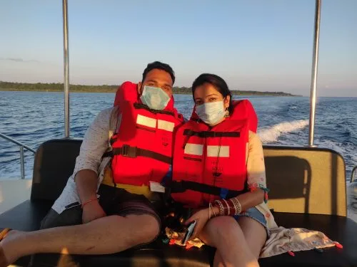 Couple souriant portant des gilets de sauvetage sur un bateau en mer