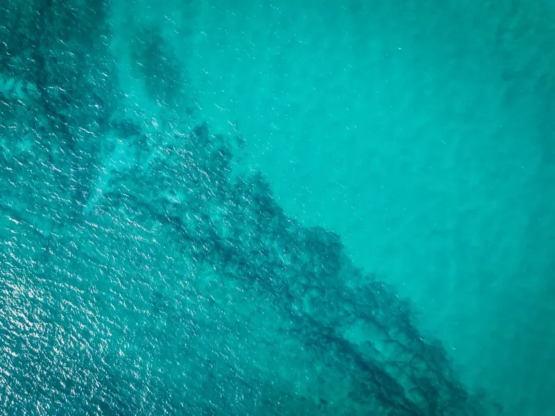 Vue aérienne de l'eau turquoise avec des motifs sous-marins
