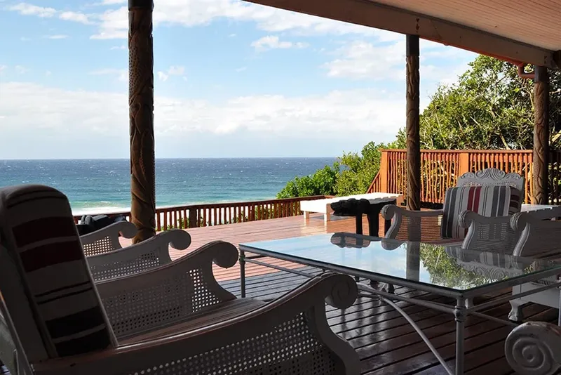 Terrasse en bois avec vue sur la mer et végétation luxuriante
