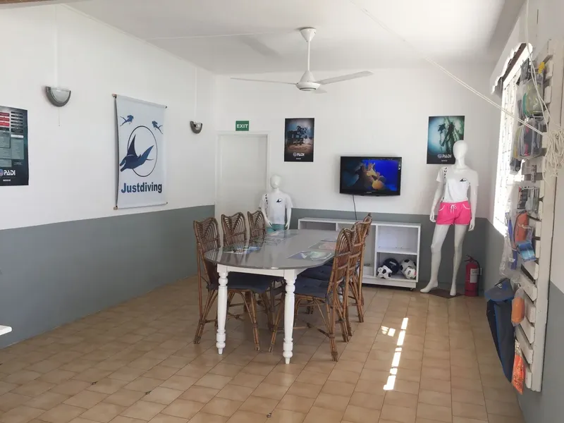 Salle d'attente d'un centre de plongée avec équipement et affiches