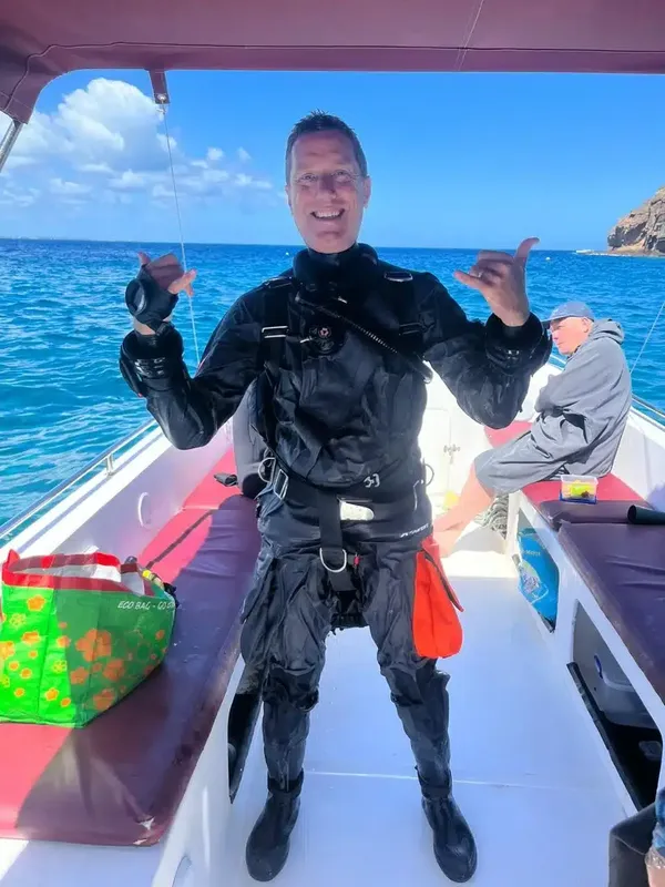 Plongeur souriant à bord d'un bateau, prêt pour une immersion