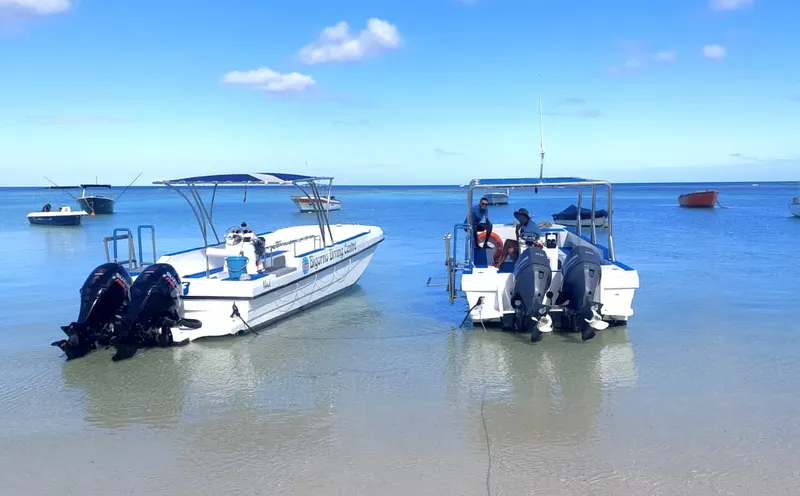 Deux bateaux de plongée amarrés dans une eau turquoise peu profonde