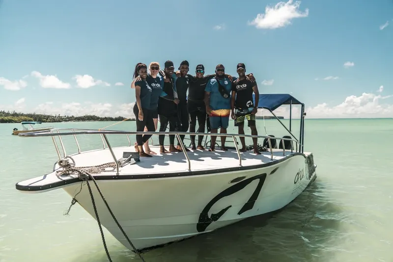 Groupe de personnes souriantes sur un bateau en mer turquoise
