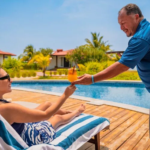 Une personne se fait servir une boisson au bord d'une piscine