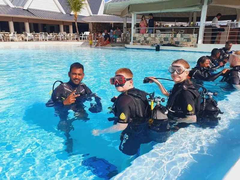 Plongeurs en formation dans une piscine, équipement complet, sourires aux lèvres