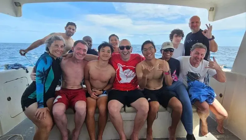 Groupe de personnes souriantes à bord d'un bateau en mer