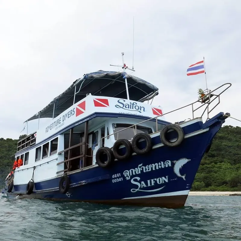 Bateau de plongée blanc et bleu naviguant sur une mer calme