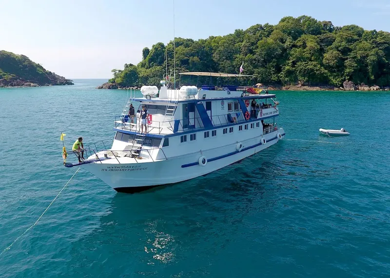 Grand bateau de plongée blanc et bleu en mer turquoise avec des passagers