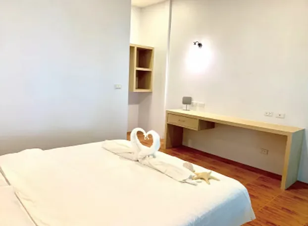 Chambre d'hôtel avec lit décoré de serviettes en forme de cygnes