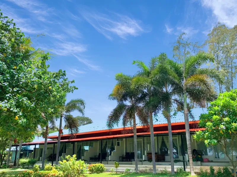 Bâtiment du centre de plongée avec pelouse, palmiers et ciel bleu