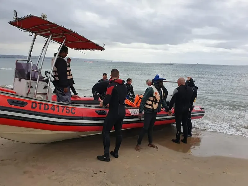 Plongée : des personnes montent à bord d'un bateau pneumatique sur une plage