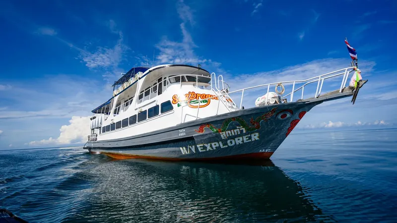 Grand bateau de plongée blanc et bleu navigue sur une mer calme