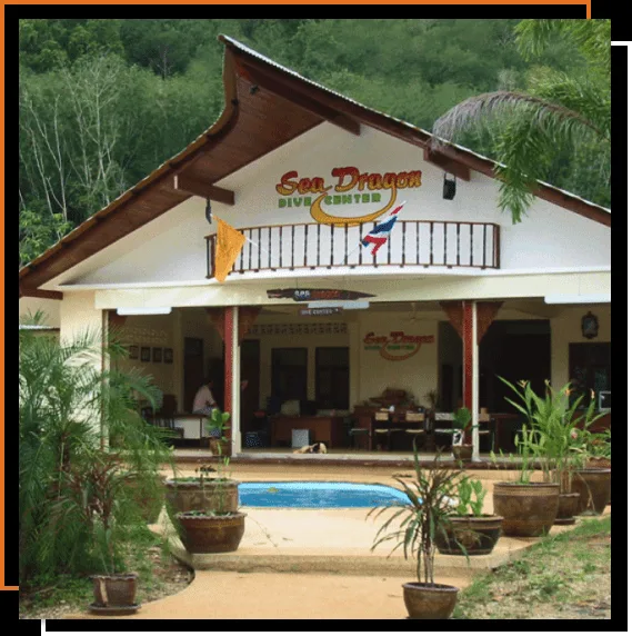 Façade d'un centre de plongée avec des personnes et de la végétation tropicale