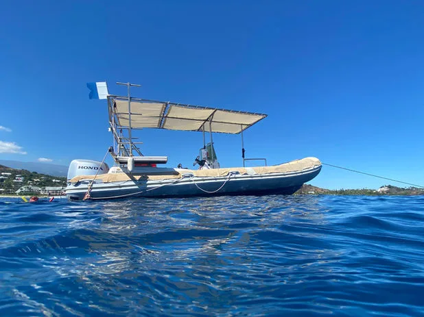 Bateau de plongée semi-rigide flottant sur une mer bleue et calme