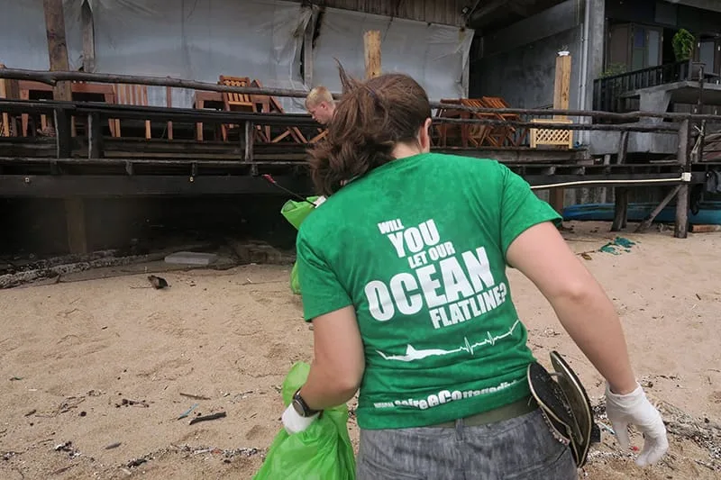Personnes ramassant des déchets sur une plage avec un message environnemental