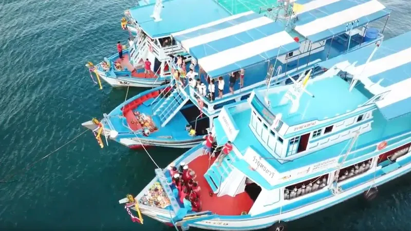 Plusieurs bateaux de plongée amarrés avec des passagers à bord