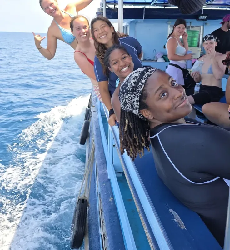 Groupe de personnes souriantes sur un bateau en pleine mer