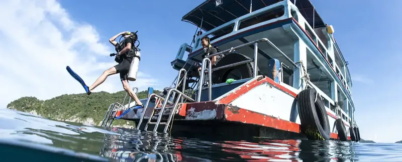 Plongeur s'apprête à sauter d'un bateau de plongée en mer