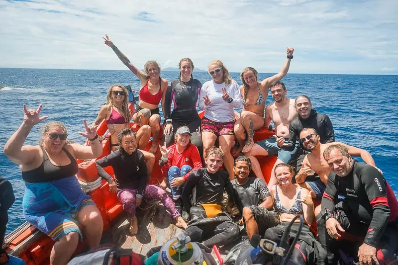 Groupe de plongeurs souriants sur un bateau en mer, joie et camaraderie