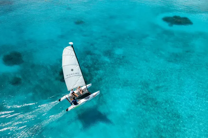Catamaran à voile navigue sur une eau turquoise et claire