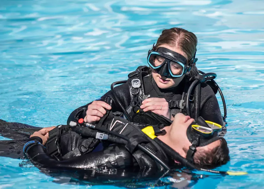Deux plongeurs en formation vérifient l'équipement dans une piscine