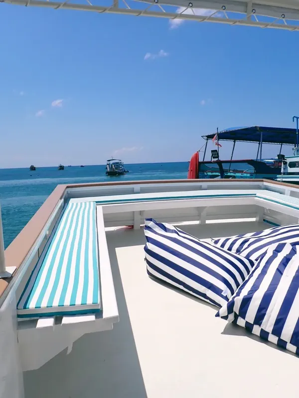 Bateau de plongée avec coussins rayés et vue sur la mer