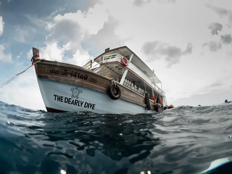 Bateau de plongée vu d'en bas, avec texte et ciel nuageux