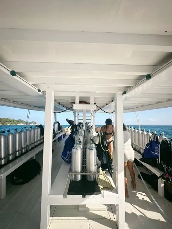 Intérieur d'un bateau de plongée avec des bouteilles et des plongeurs