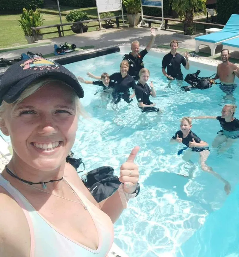 Groupe de personnes en combinaison de plongée dans une piscine