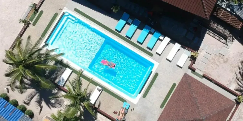 Vue aérienne d'une piscine avec des personnes se relaxant au soleil