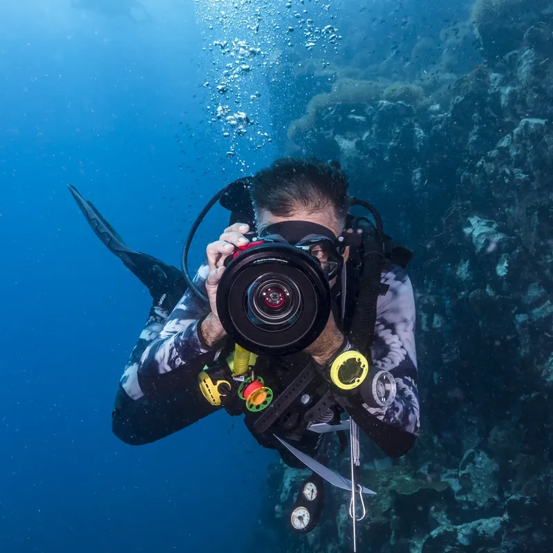 Plongeur photographiant sous l'eau avec un appareil photo professionnel