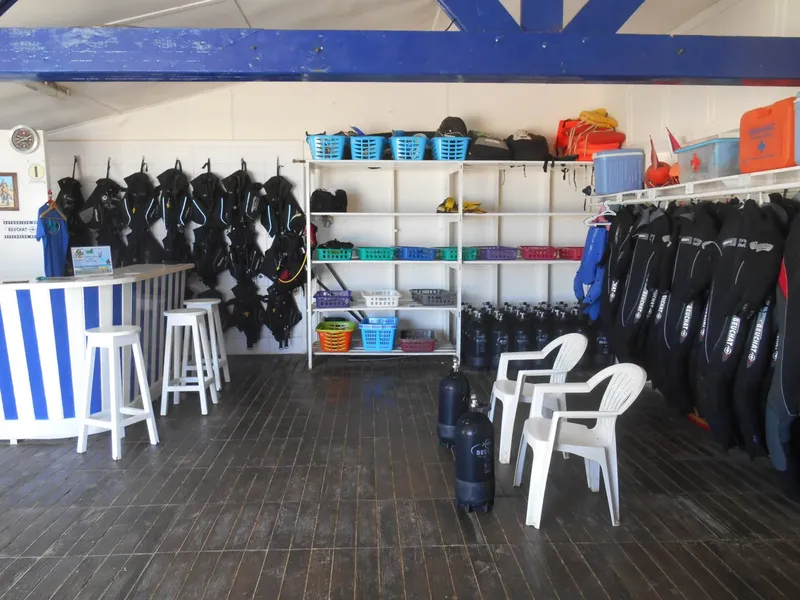 Intérieur d'un centre de plongée avec combinaisons, bouteilles et matériel