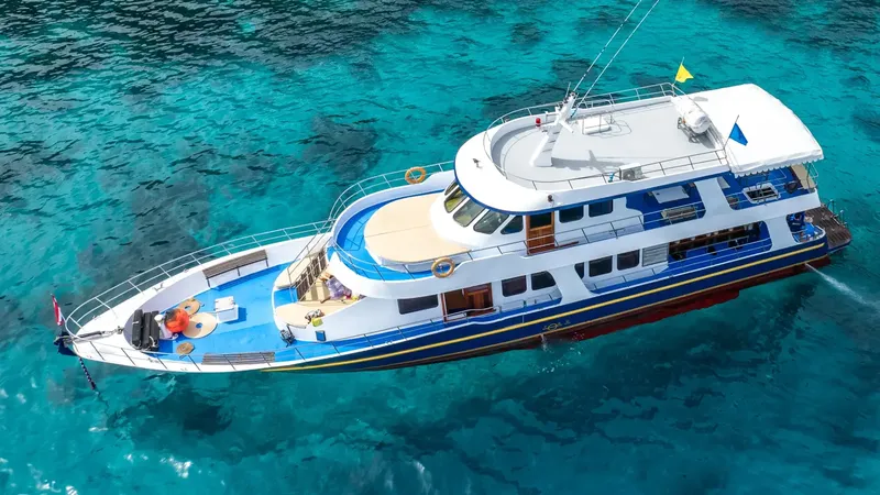 Grand bateau de plongée blanc et bleu navigue sur mer turquoise