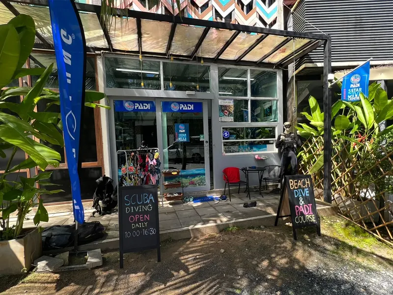 Façade d'un centre de plongée avec équipement et personnes devant