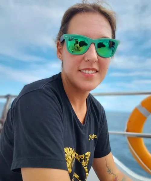 Femme souriante portant des lunettes de soleil sur un bateau en mer