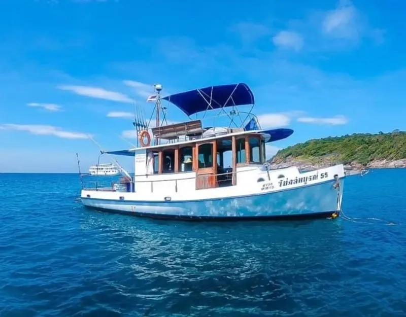 Bateau de plongée traditionnel sur une mer bleue sous un ciel clair