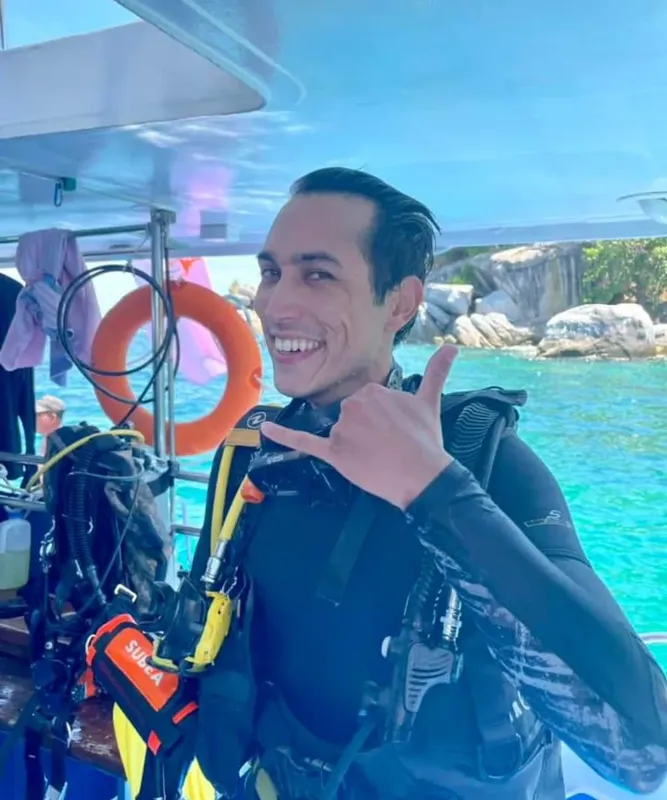 Plongeur souriant sur un bateau, prêt pour une immersion en mer